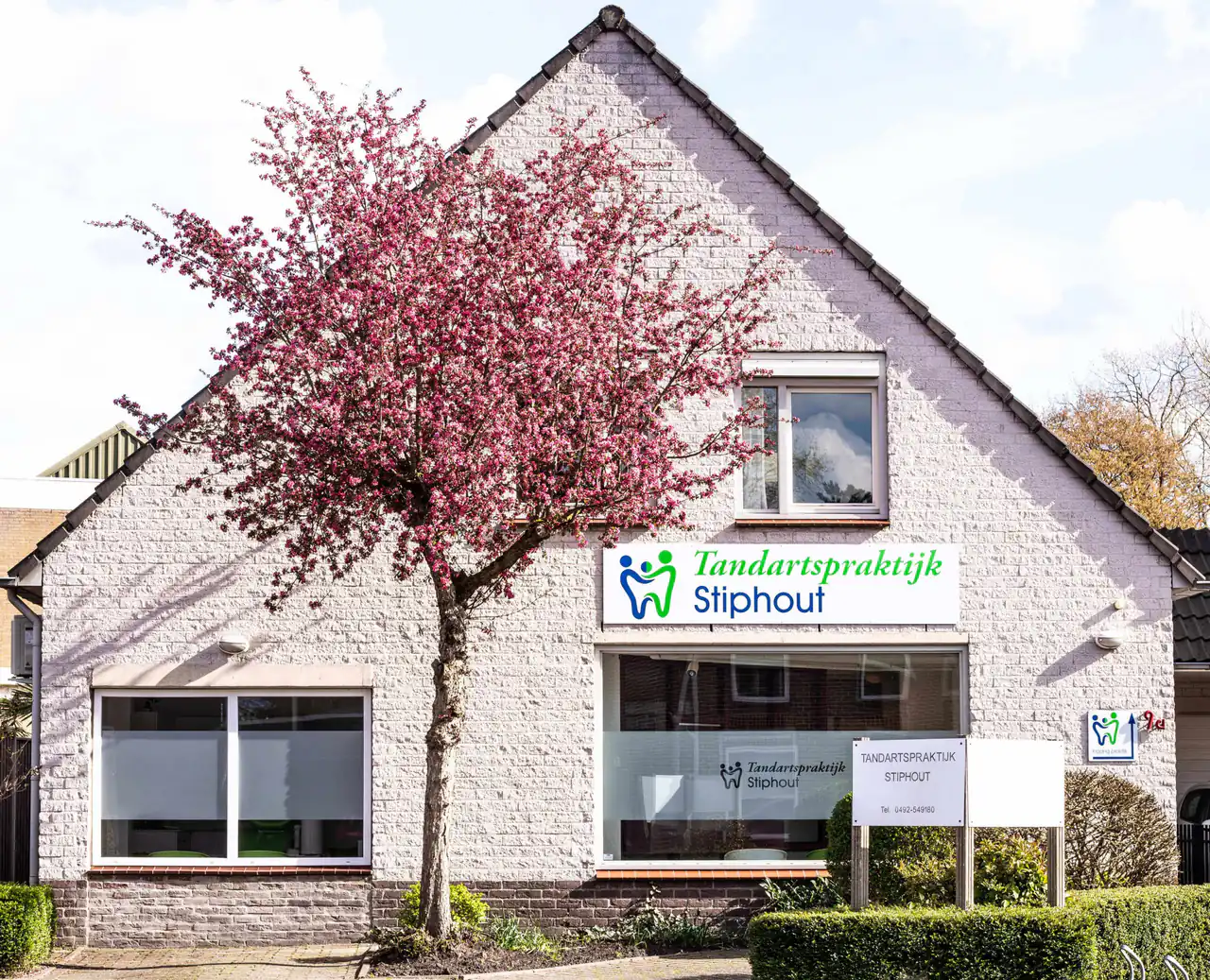 Het pand van Tandartspraktijk Stiphout aan de Gerwenseweg 9a in Helmond, met de bloeiende sierkers voor de gevel